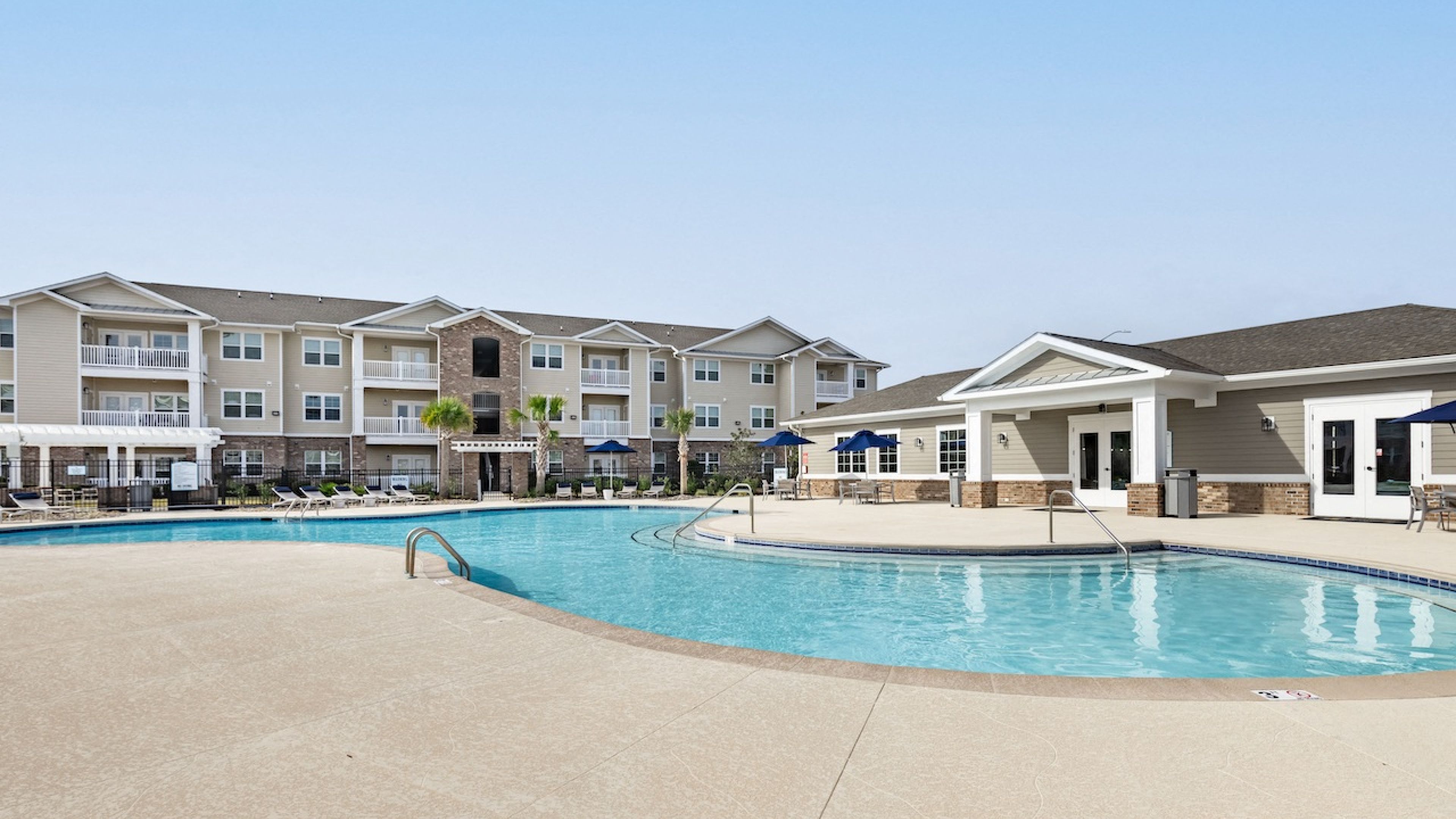 Resort-like poolside view with vibrant landscaping at Hawthorne at Stillwater, epitomizing luxury apartment living in Sneads Ferry, NC
